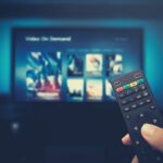 hand hiolding the remote control for best anti-glare TV